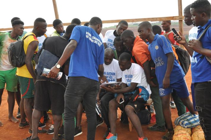 After the training session, the footballers gather around and the OEMIT volunteers begin to share their stories
