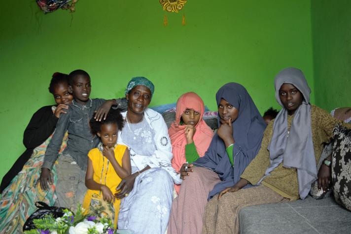 Asha’s husband with their children and grandchildren at the doorstep of their house