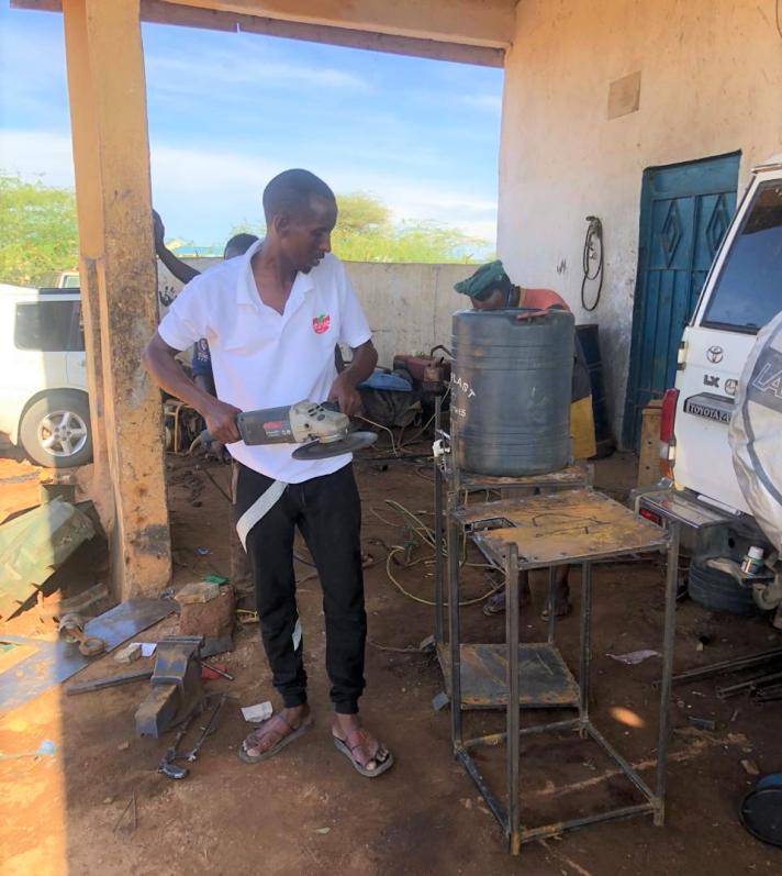 Abdikadir Adan in the process of making a handwashing station. Dollow, Somalia. April 2020.