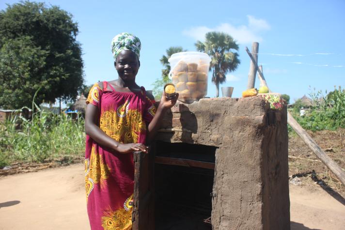 Harriet Juru in front of her oven © Tumuhairwe Diana Sharone/GIZ