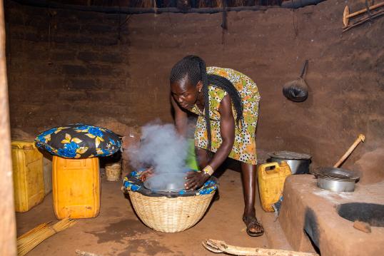 Lilias preparing food in a basket stove © Save the Children Uganda