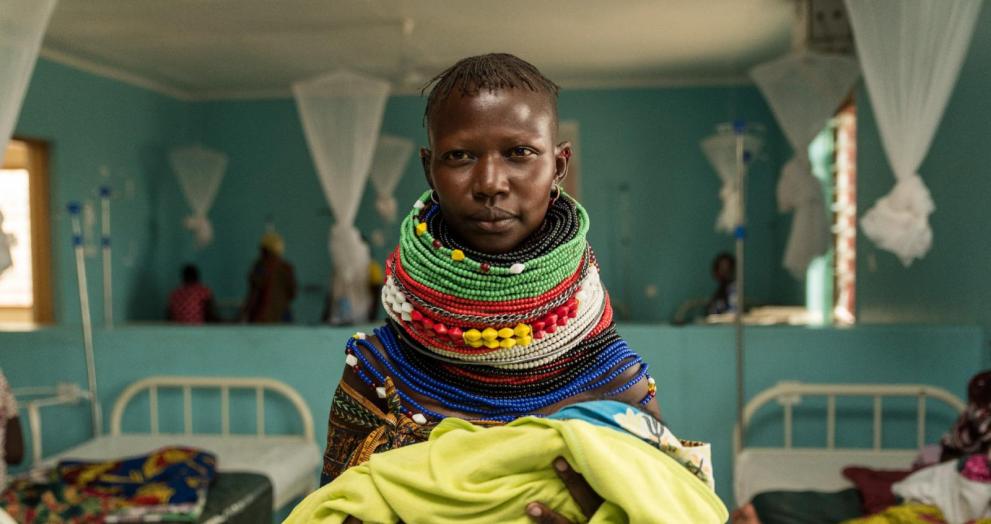 A Turkana woman poses for a photo with her new born at the Kalobeyei maternity. The maternity is accessed by refugees and Kenyans alike.