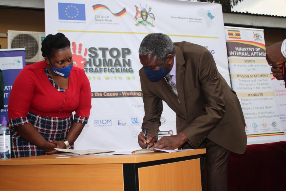 Uganda State Minister for Internal Affairs, M. Kania Mario Obiga, signs the National Action Plan for Prevention of Trafficking in Persons,