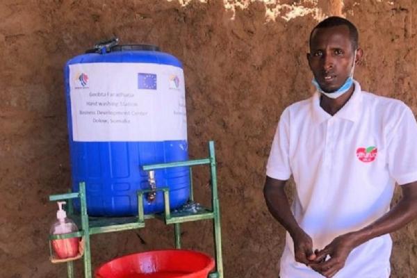 Abdikadir Adan in the process of making a handwashing station. Dollow, Somalia. April 2020.